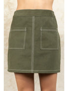Green skirt with two front pockets on a neutral background