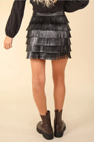 Back view of black fringe mini skirt showing layered movement and mini length