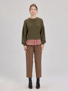 Woman in a olive round-neck textured knit oversized top with drop shoulders and long sleeves, relaxed fit.