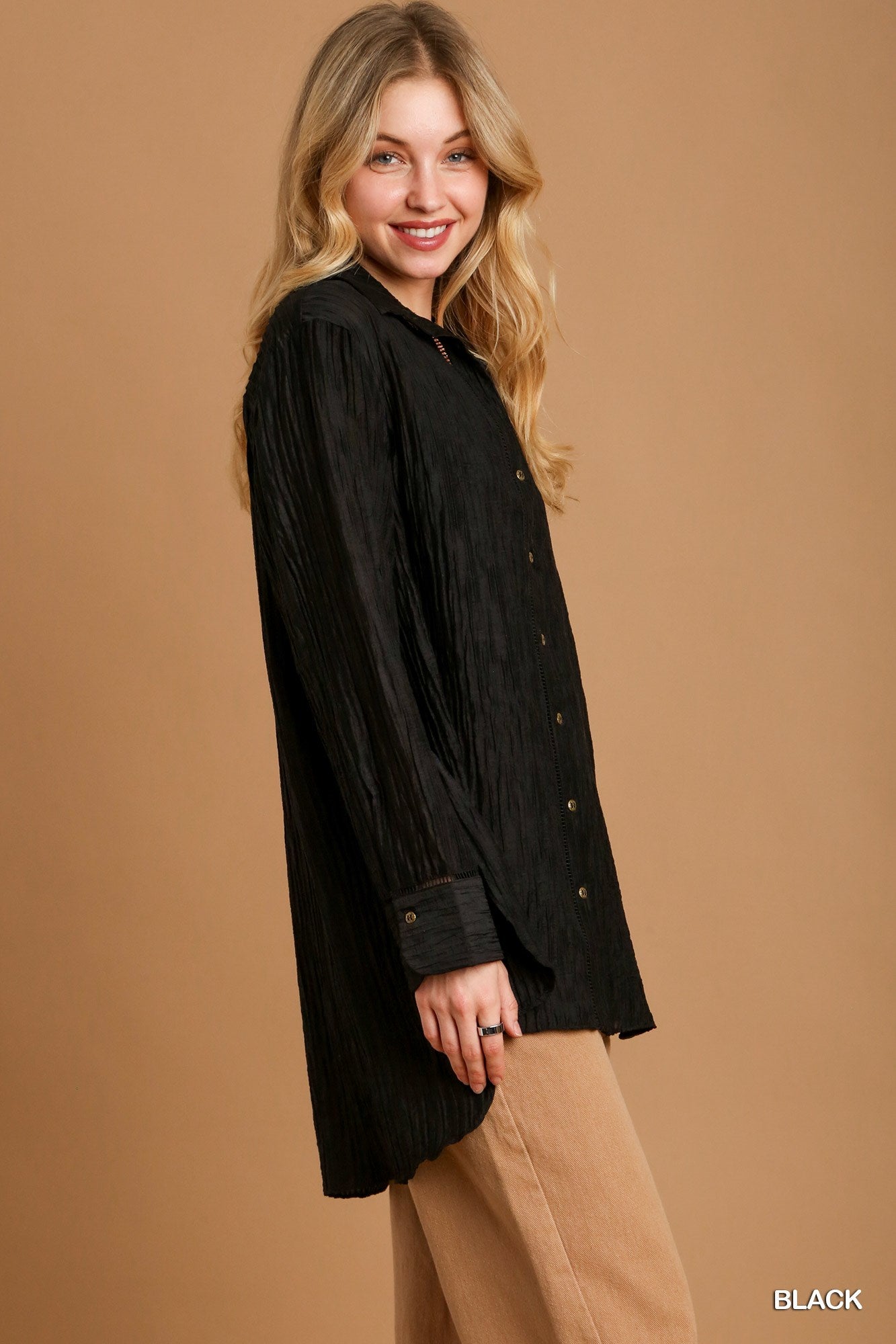 Woman wearing a black blouse against a brown background