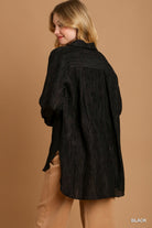 Woman wearing a black textured shirt against a brown background
