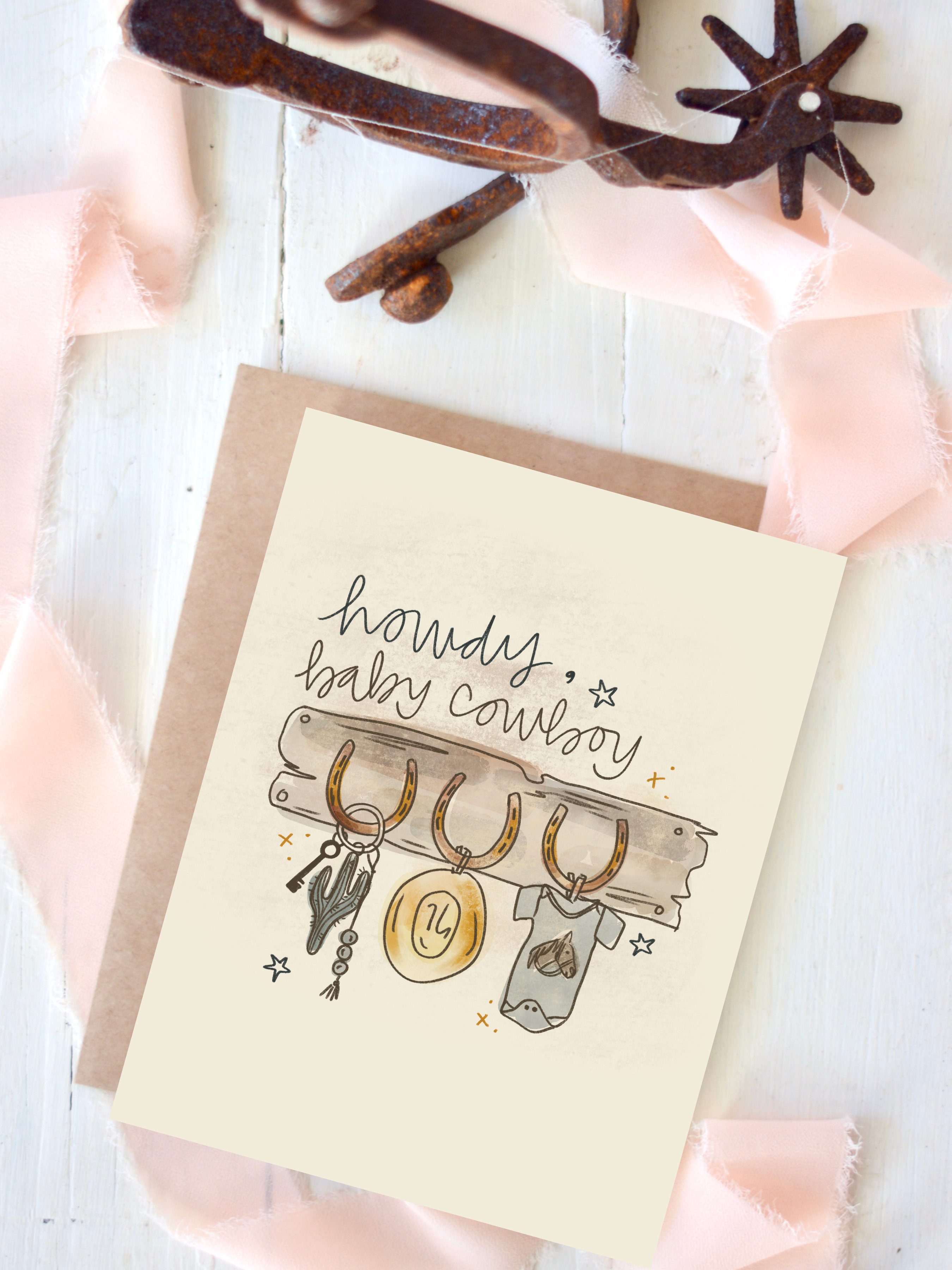 Card with 'howdy, baby cowboy' text and illustrations on a white background