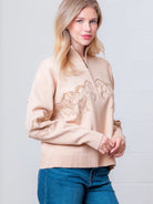 Taupe high-neck quarter-zip sweater with horse embroidery on model, front view.