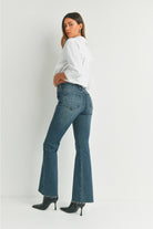 Woman wearing blue jeans and a white shirt on a white background