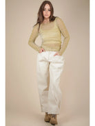 Front view: Model wearing champagne sheer lurex long-sleeve fitted top with crew/mock neck; subtle sparkle visible.