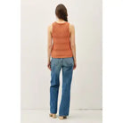 Back view Person wearing an rust sleeveless top and blue jeans on a white background