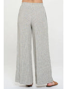 Light gray pin stripped pants worn with elastic  waist by a person 