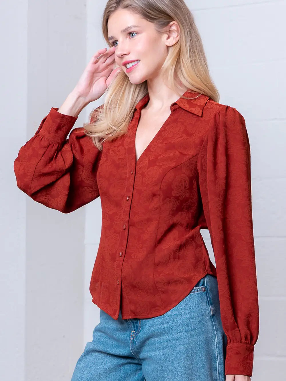 Front view of rust Western-inspired embossed blouse showing tailored waist and button front.