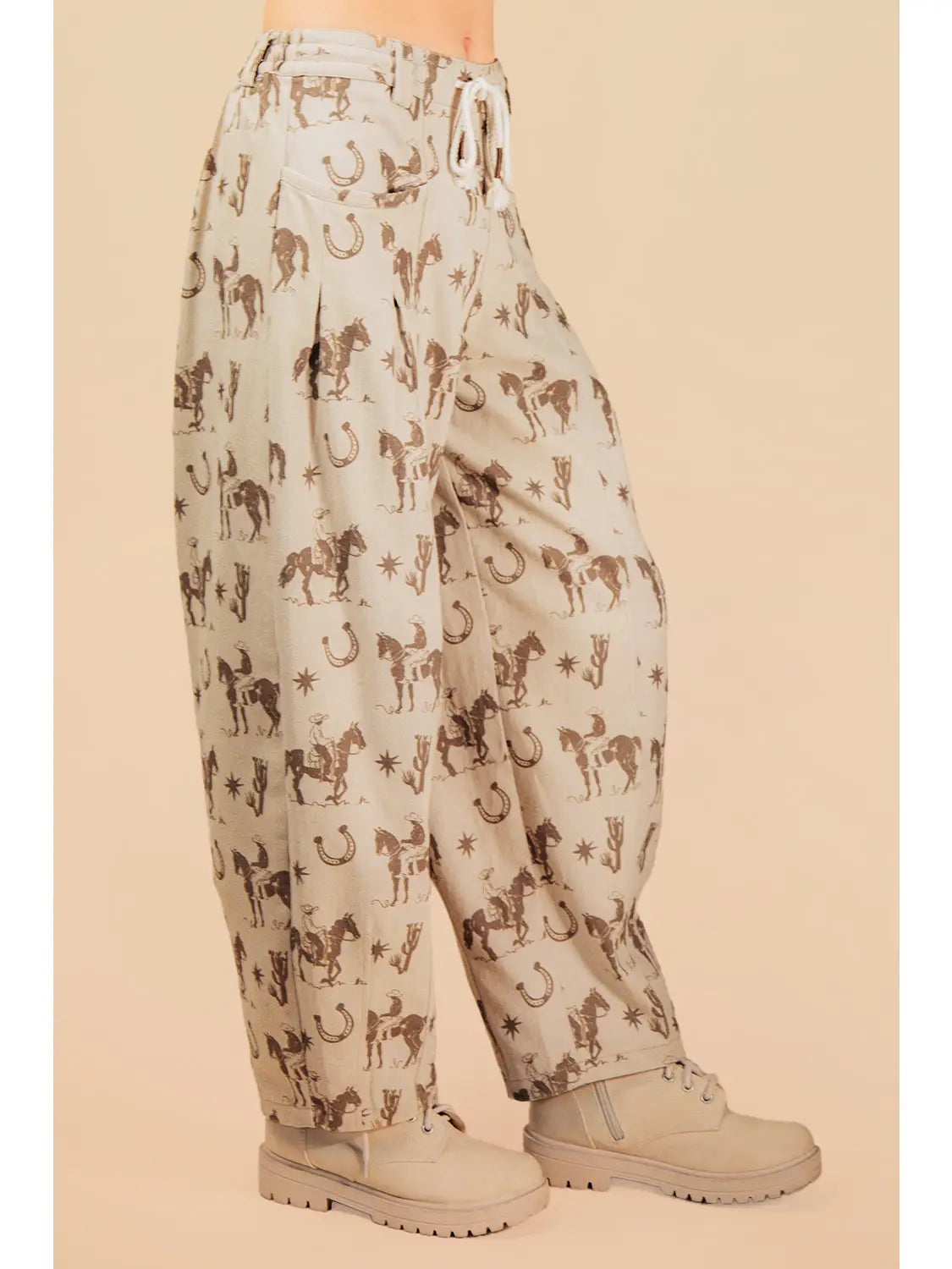 Light-colored pants with horse print worn by a person on a beige background