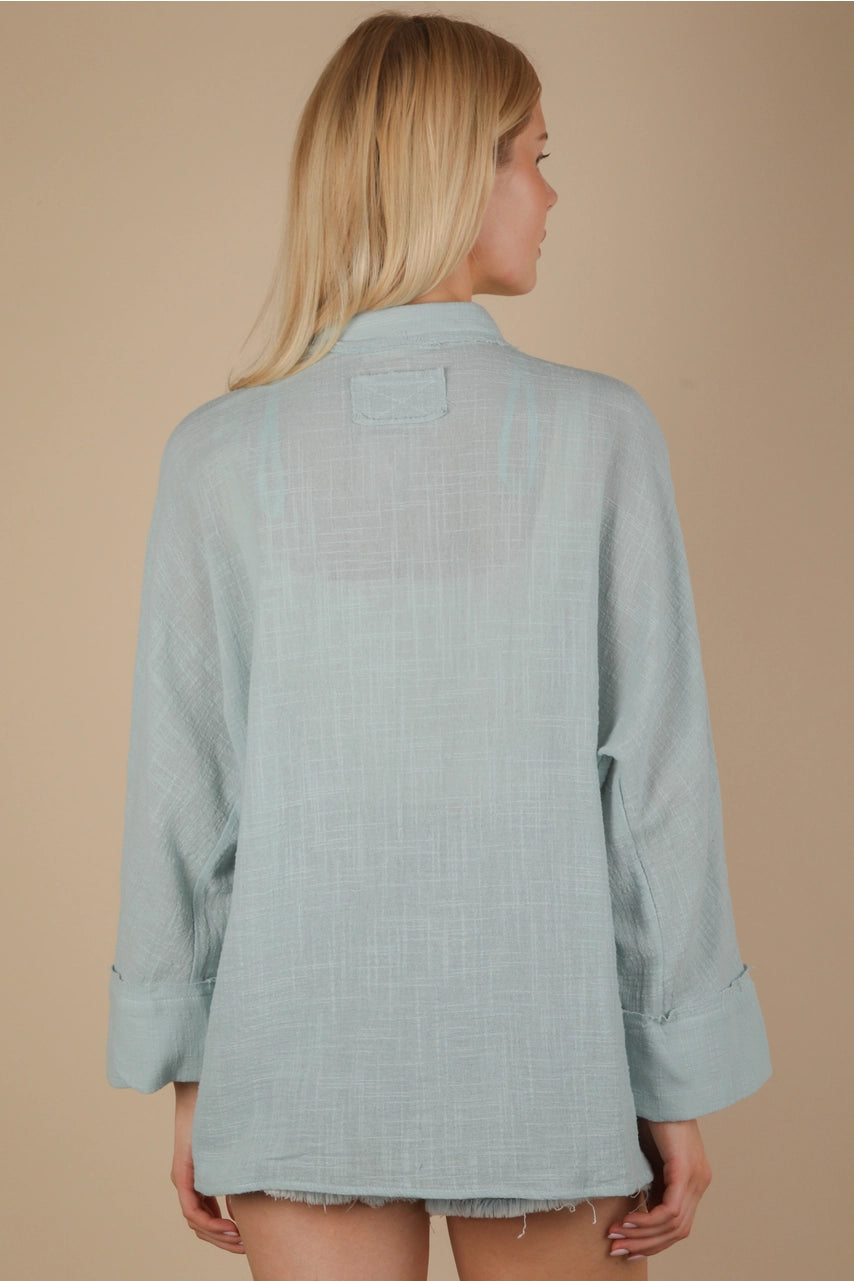 Back view of oversized gauze button-down with dolman sleeves