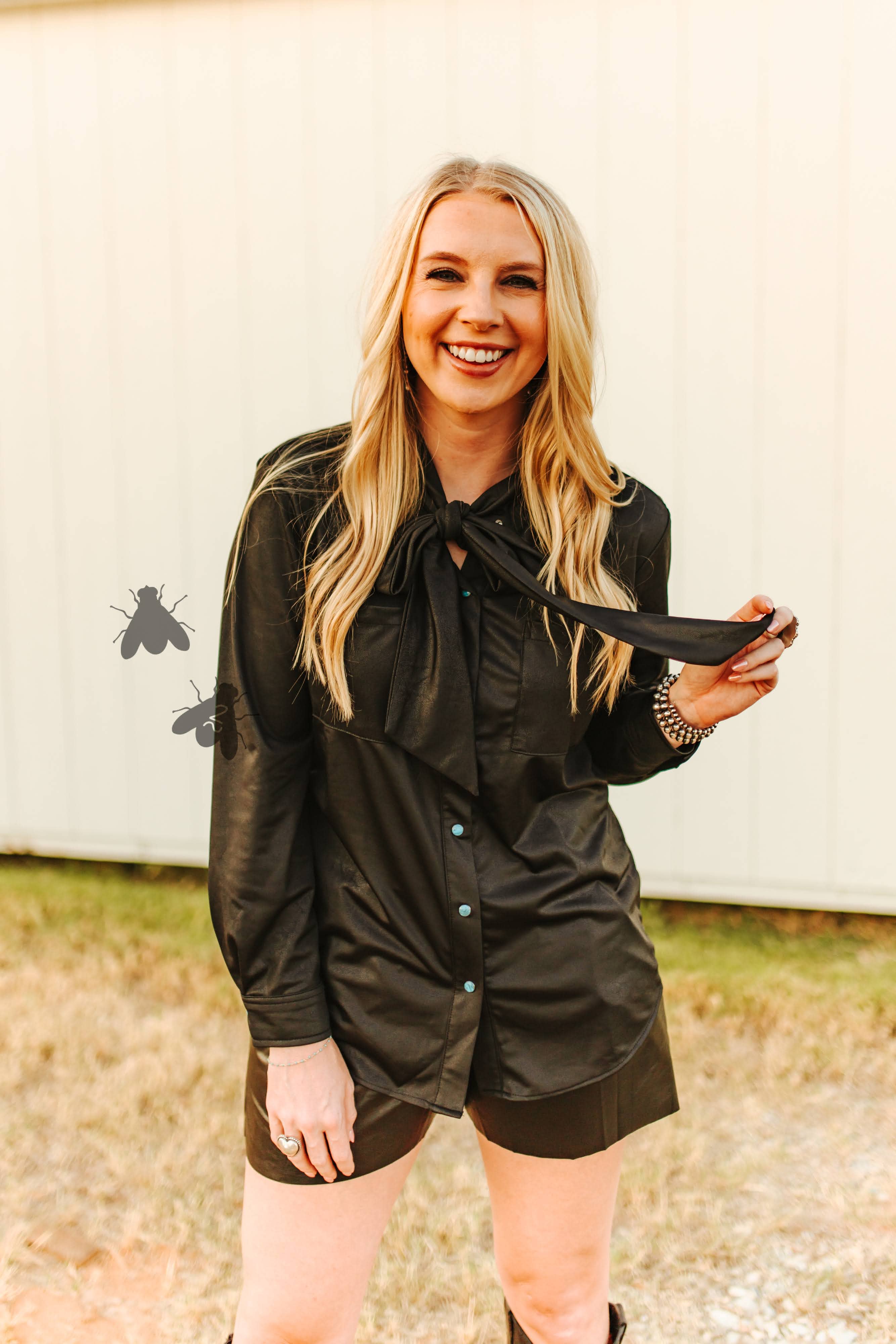 Woman in a black shirt and shorts outfit outdoors.