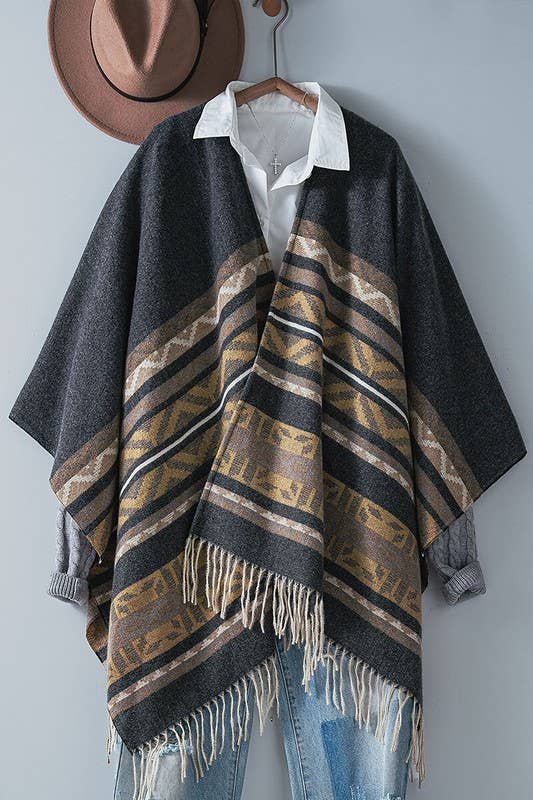 Dark gray poncho with brown and beige striped pattern and fringes on a white background