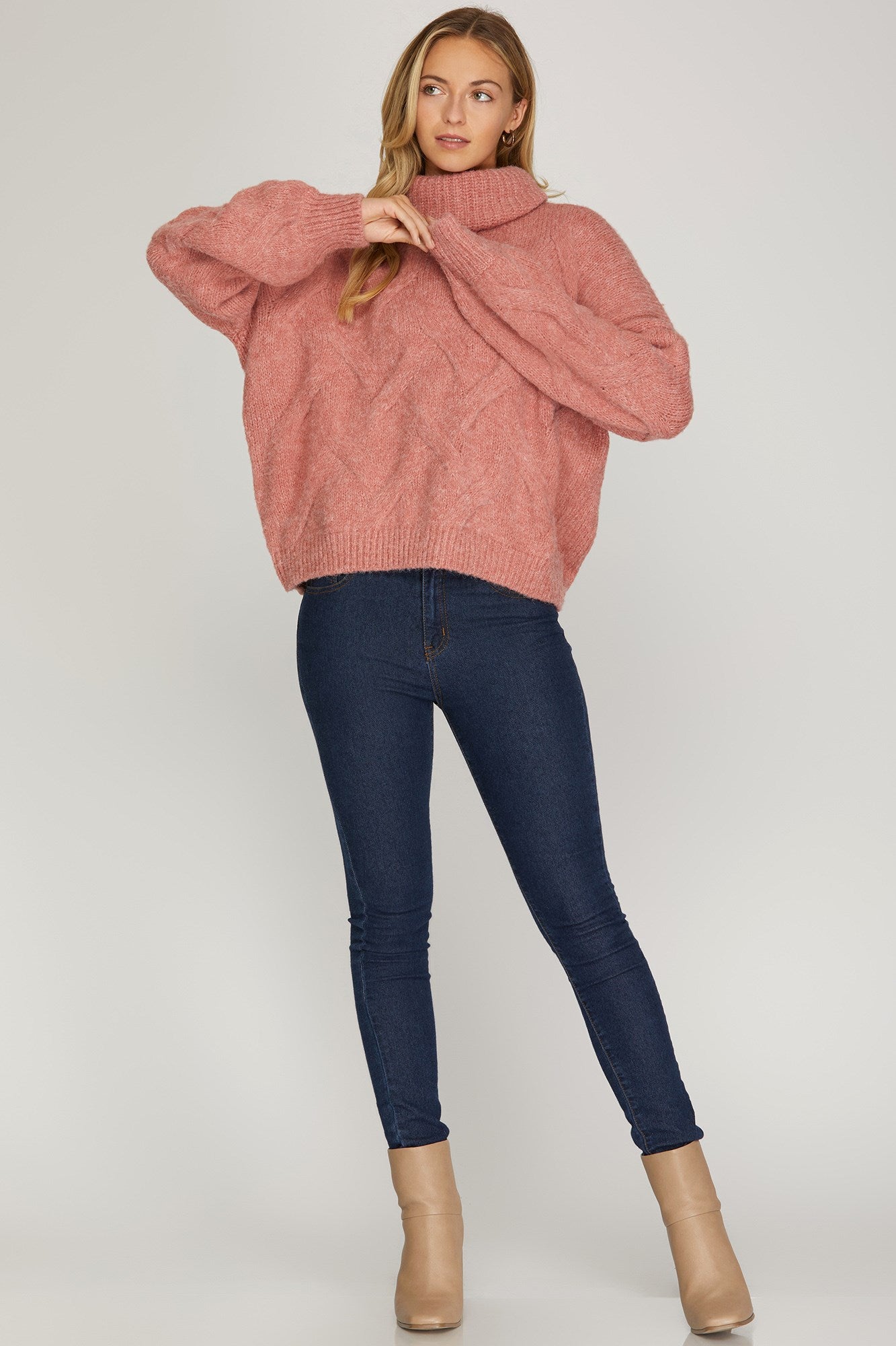 Front view of rosy-rust cable knit turtleneck sweater with ribbed cuffs and hem.