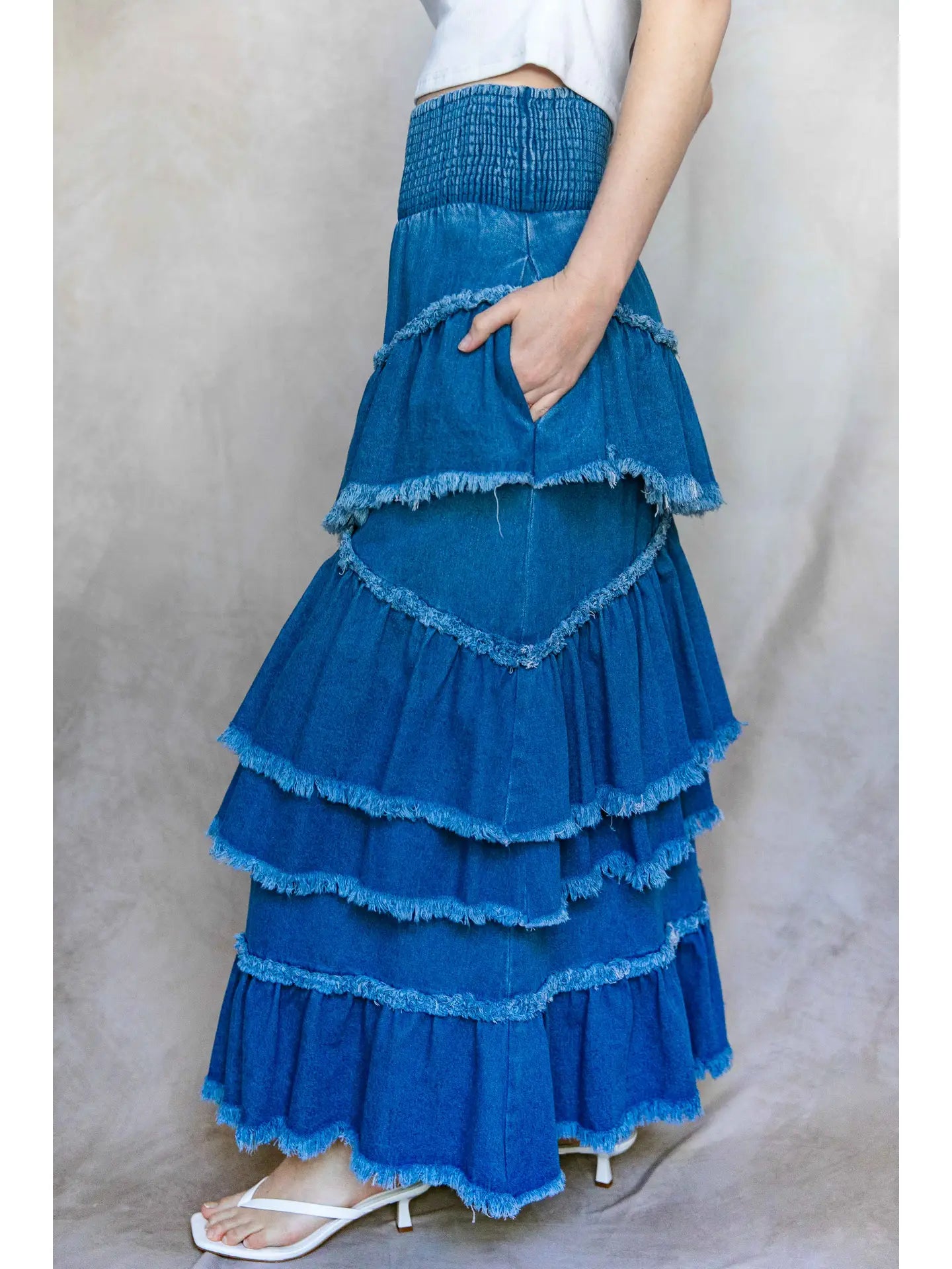 Blue tiered skirt worn by a person on a plain background