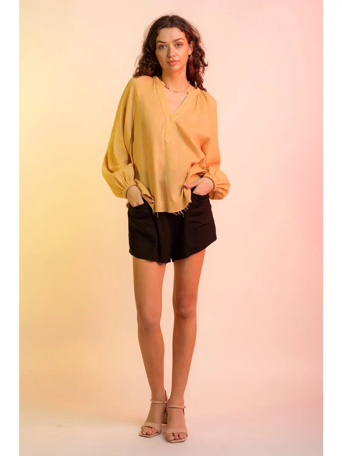 Front view, relaxed pose: Yellow V-neck gauze blouse with raw edge hem and billowy sleeves, model facing camera.