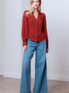 Front view of rust Western-inspired embossed blouse showing tailored waist and button front.