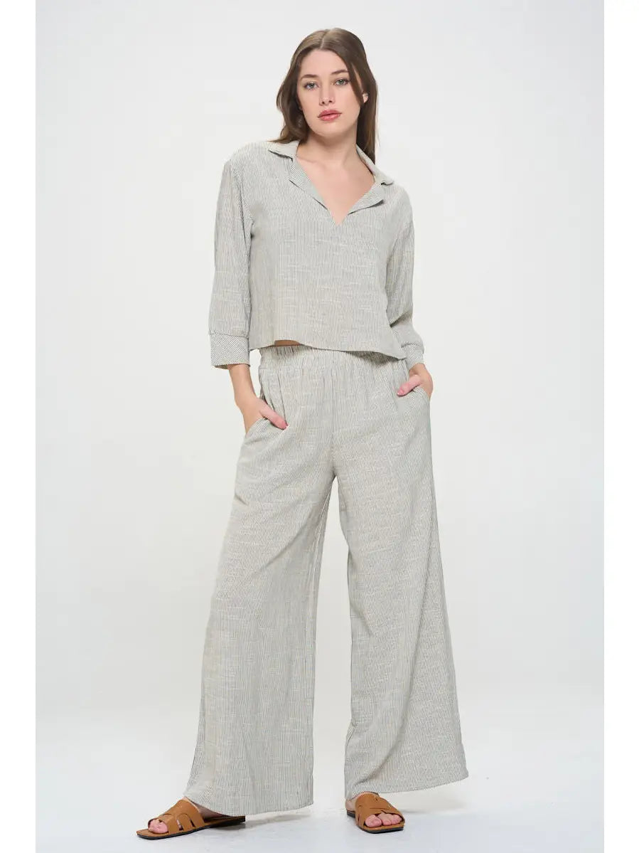 Light gray pin stripped pants worn with elastic  waist by a person 
