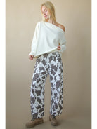Front view of solid boat-neck cotton knit top worn slightly off-shoulder, long sleeves