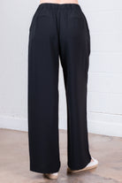 Black wide-leg pants on a neutral background