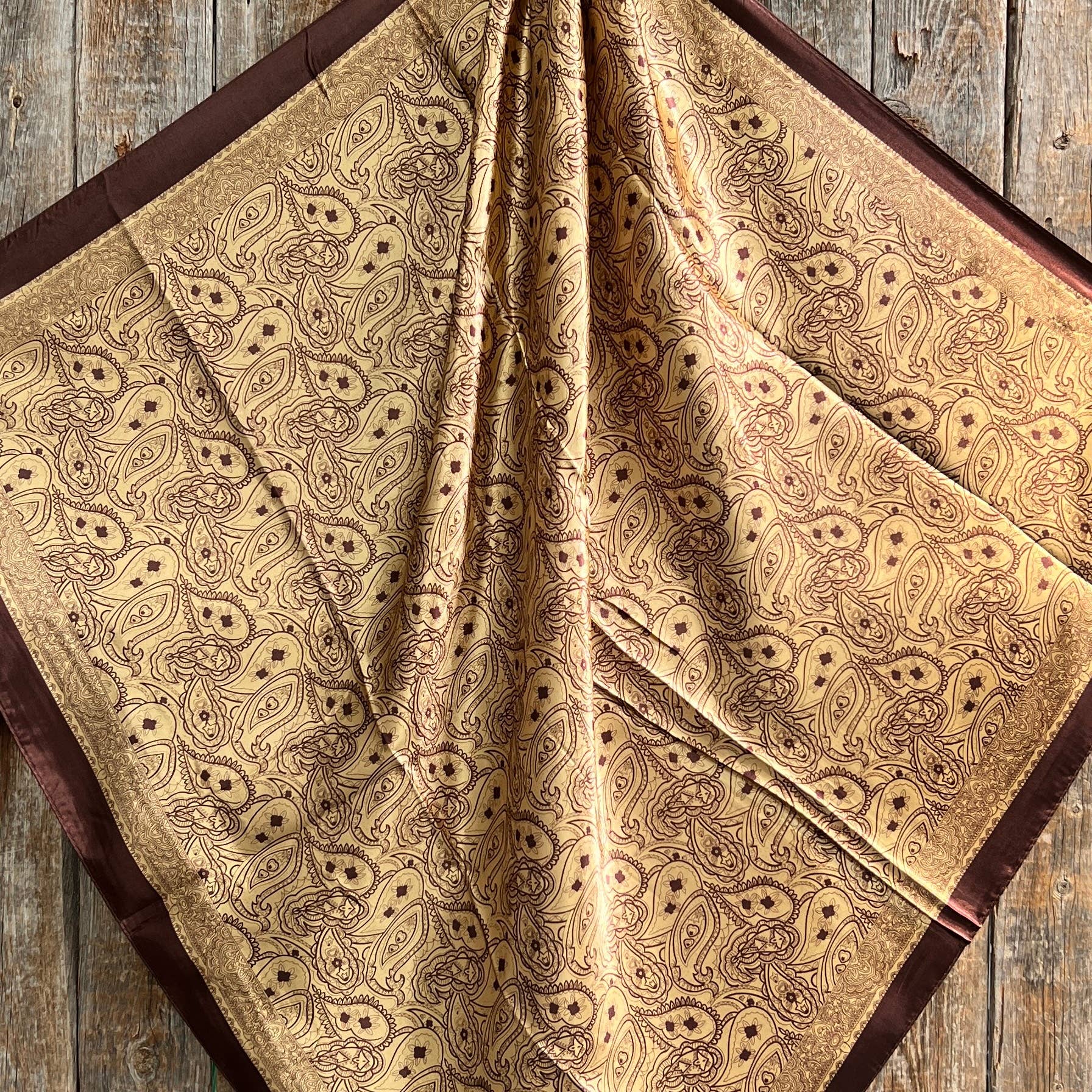 Patterned fabric with brown and beige colors on a wooden surface