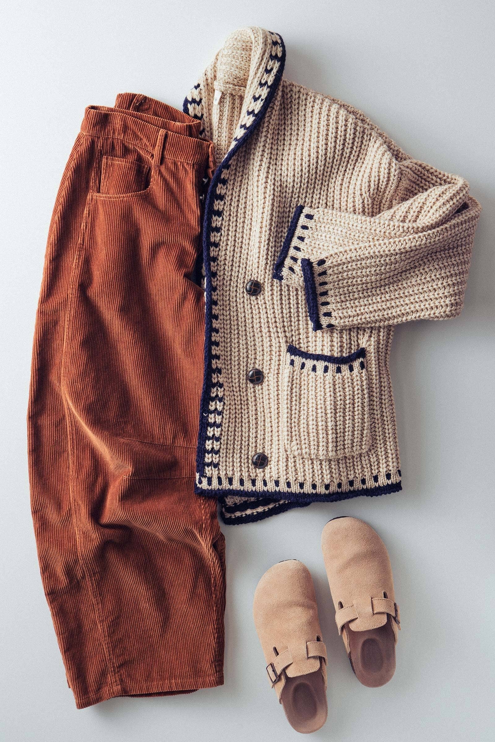 Knitted beige cardigan, brown pants, and tan shoes on a light gray background
