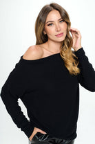 Woman wearing a black off-shoulder sweater on a white background