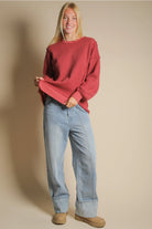Front view of burgundy oversized waffle knit top with round neck and drop shoulders.