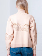 Back view of taupe quarter-zip sweater showing relaxed drape and rib hem