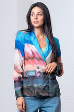 Woman wearing a colorful blazer with a neutral background