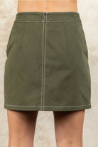 Green skirt worn by a person on a neutral background