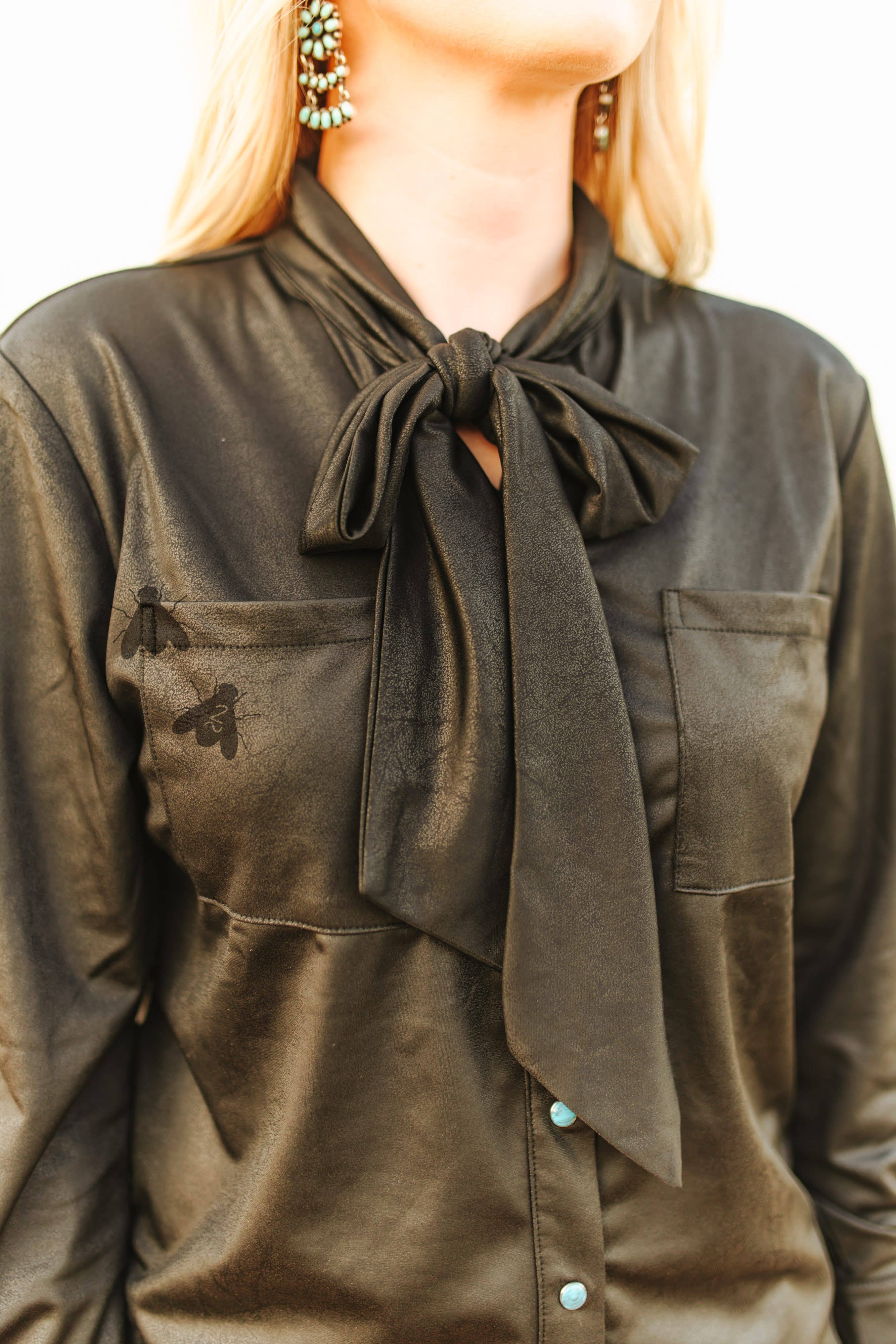 Black faux leather shirt with a bow tie worn by a person