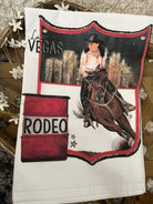 Tea towel with a rodeo design featuring a cowgirl on a horse and a barrel, with 'Las Vegas Rodeo' text.