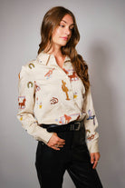 Woman wearing a Woman wearing a western embroidery patterned shirt with a gray background