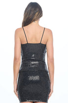Black sequin tank and skirt worn by a model on a white background