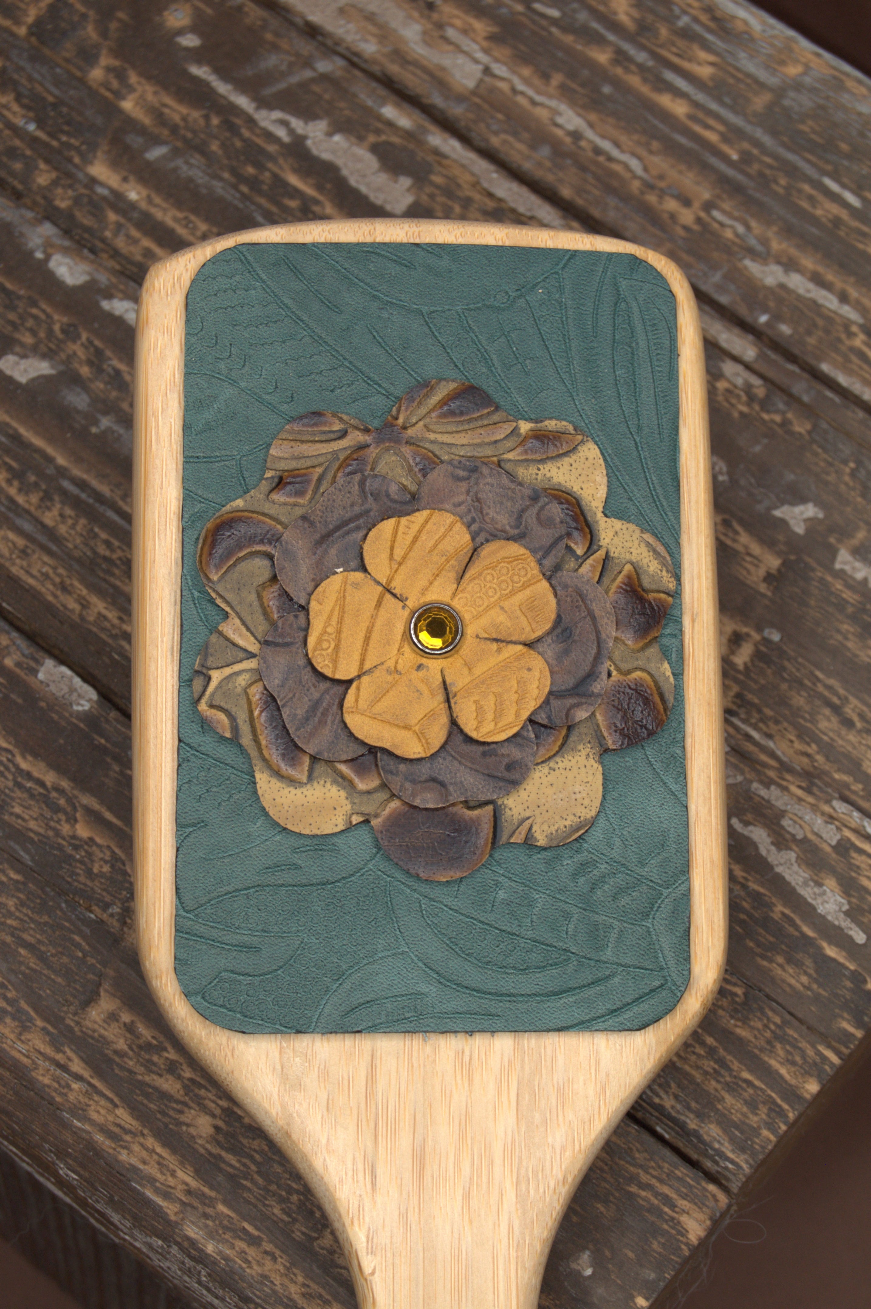 Leather accented hair brush with leather flower.