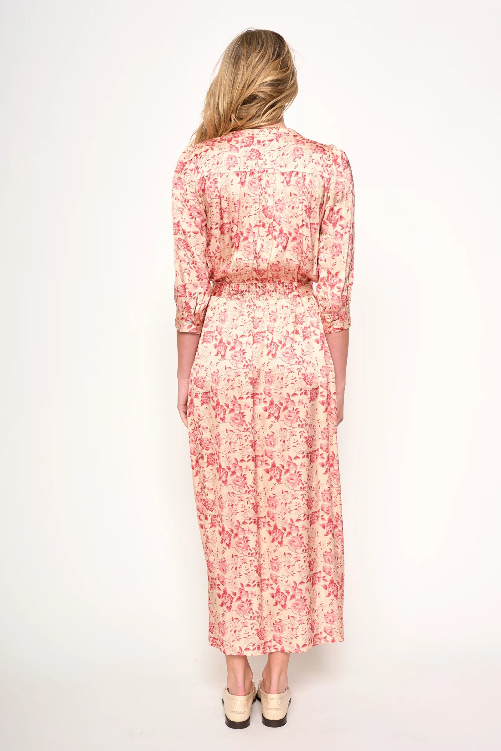 Woman wearing a red floral dress on a white background