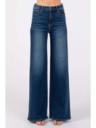 A pair of dark denim high-rise super wide leg jeans displayed on a model without showing the upper part of the body.