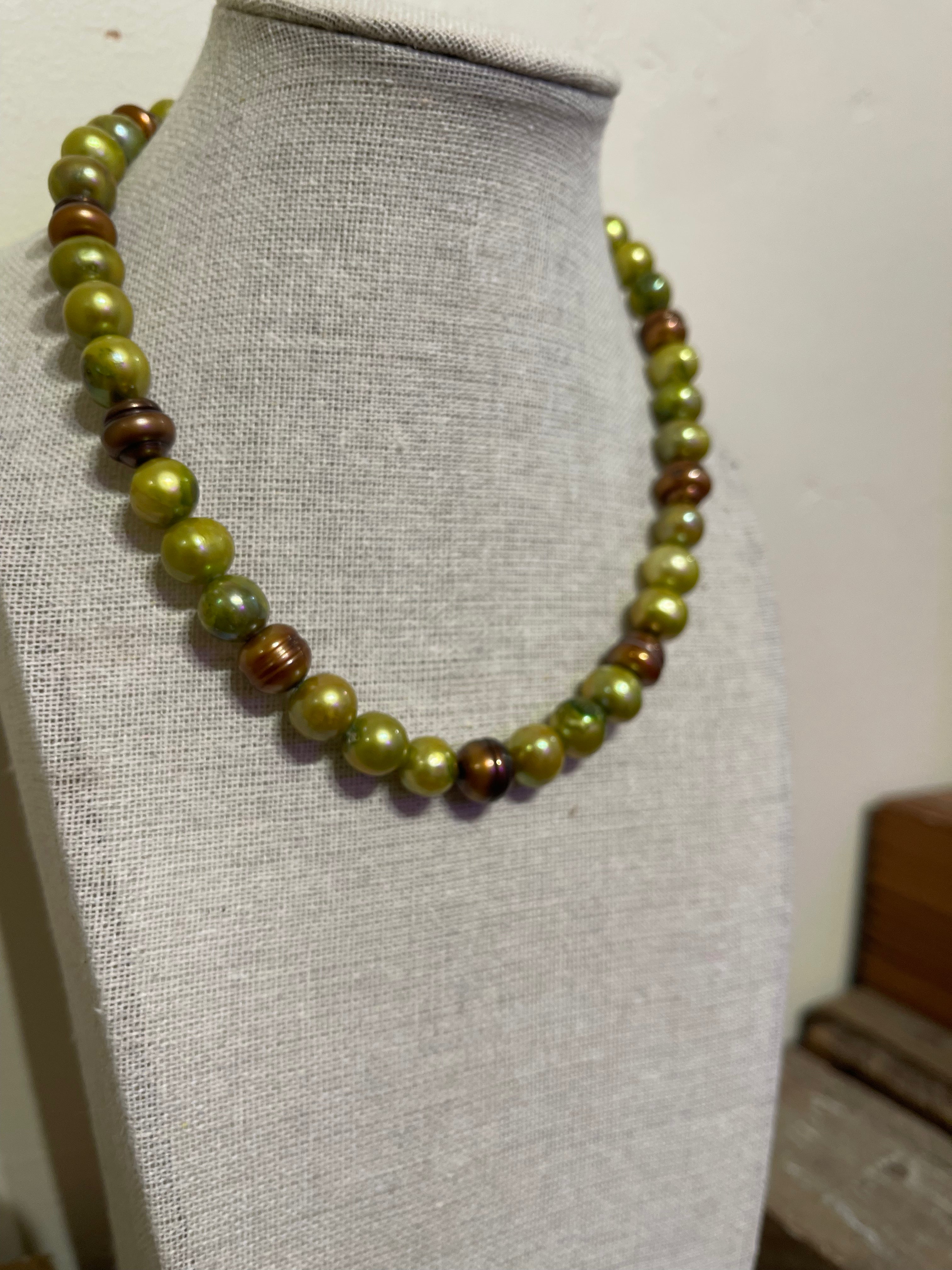 Necklace with green and brown 10mm freshwater pearls on a mannequin bust.