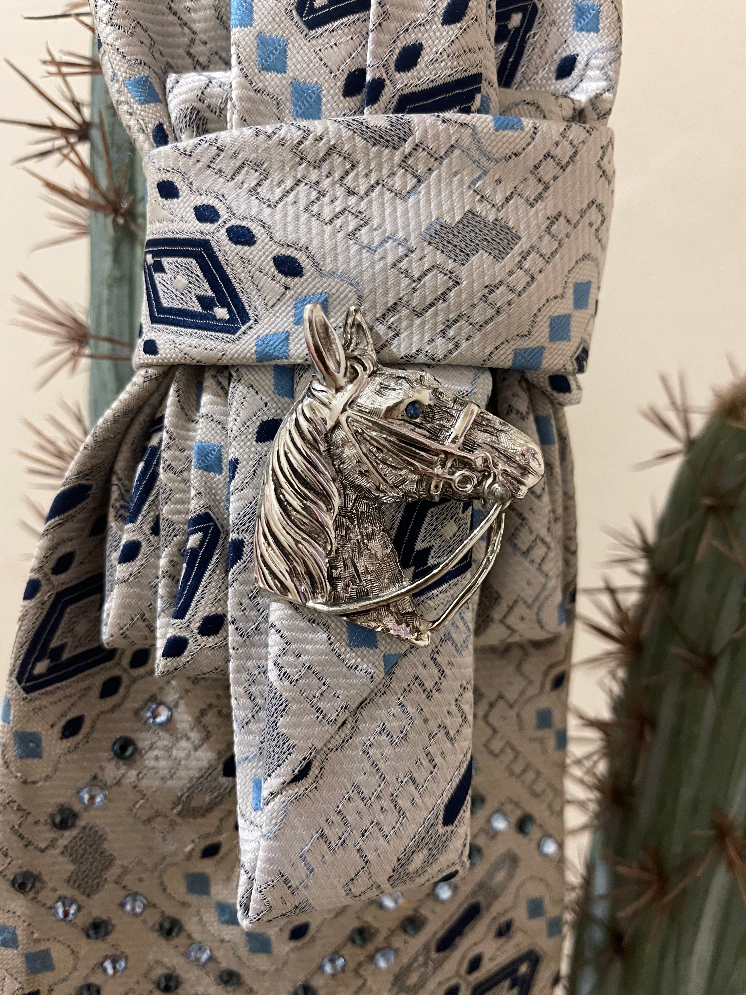 Handcrafted vintage tie necklace by Copper &amp; Lace Western Boutique featuring an authentic 1970s silver, navy, and blue patterned necktie with rhinestone embellishments, vintage silver horse head brooch, and ornate silver chain.