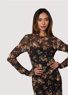 Woman wearing a floral dress against a plain background