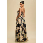 Woman wearing a floral strapless gown against a beige background