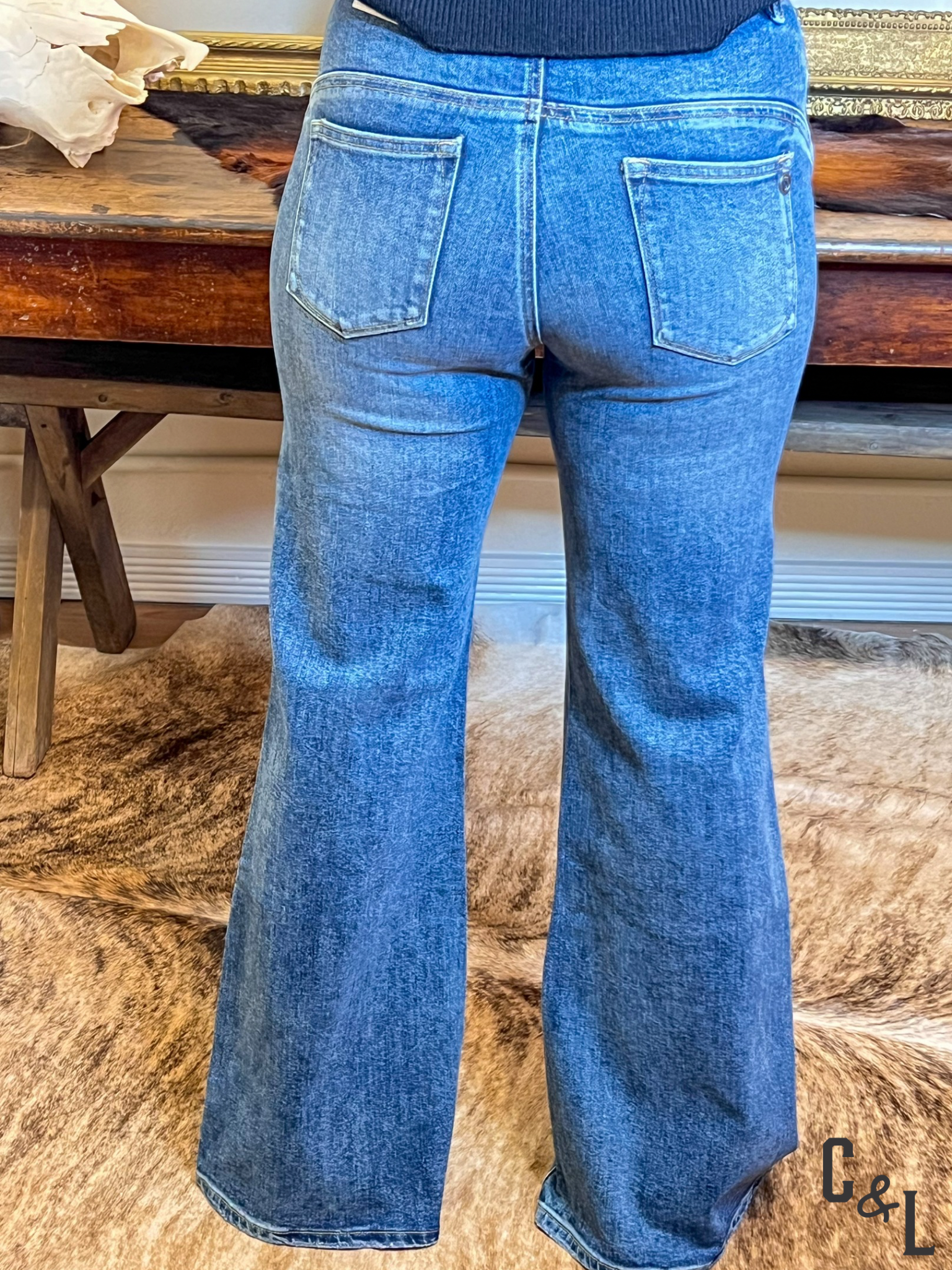 Blue flared jeans on a wooden surface with a blurred background