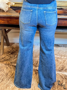 Blue flared jeans on a wooden surface with a blurred background