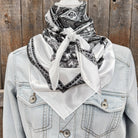 Light blue denim jacket with a white bandana and black paisley pattern against a wooden background