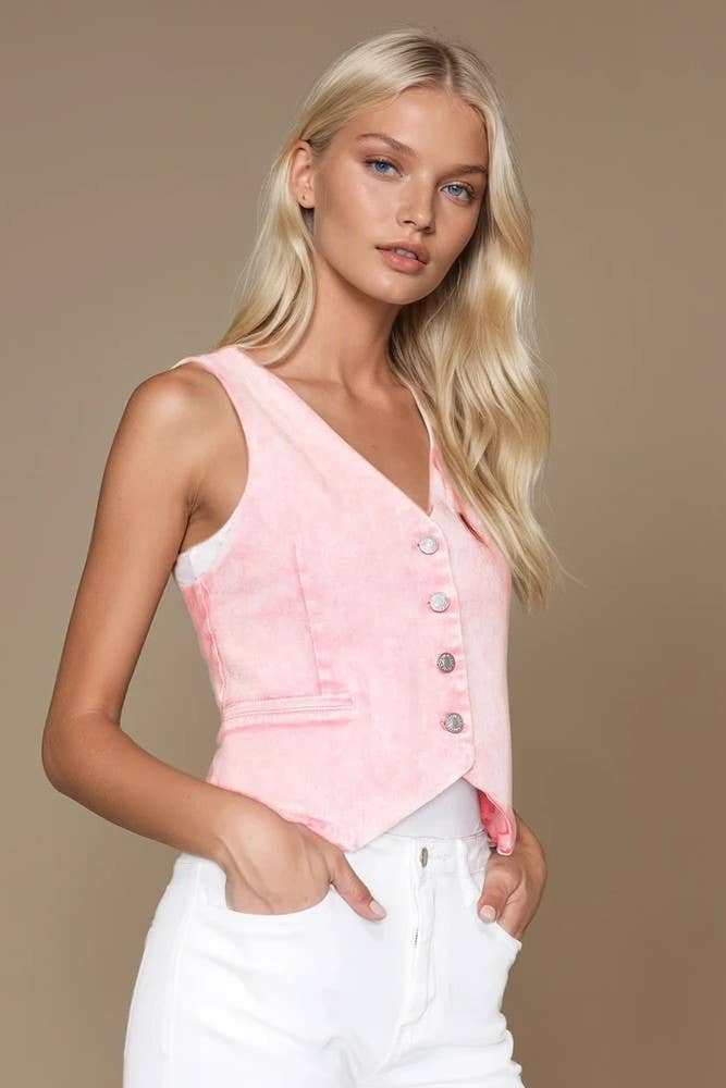 Woman wearing a pink sleeveless top with buttons against a beige background
