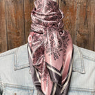 Person wearing a pink and grey patterned scarf with a wooden background