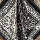 Black and white paisley patterned fabric on a wooden surface