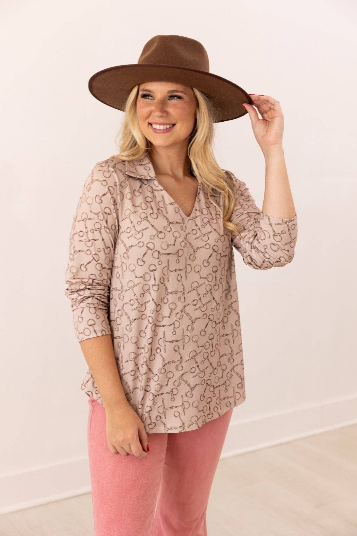 Front view of V-neck stretch top with roll-tab sleeves in a relaxed fit tan with brown horse bit pattern all over top