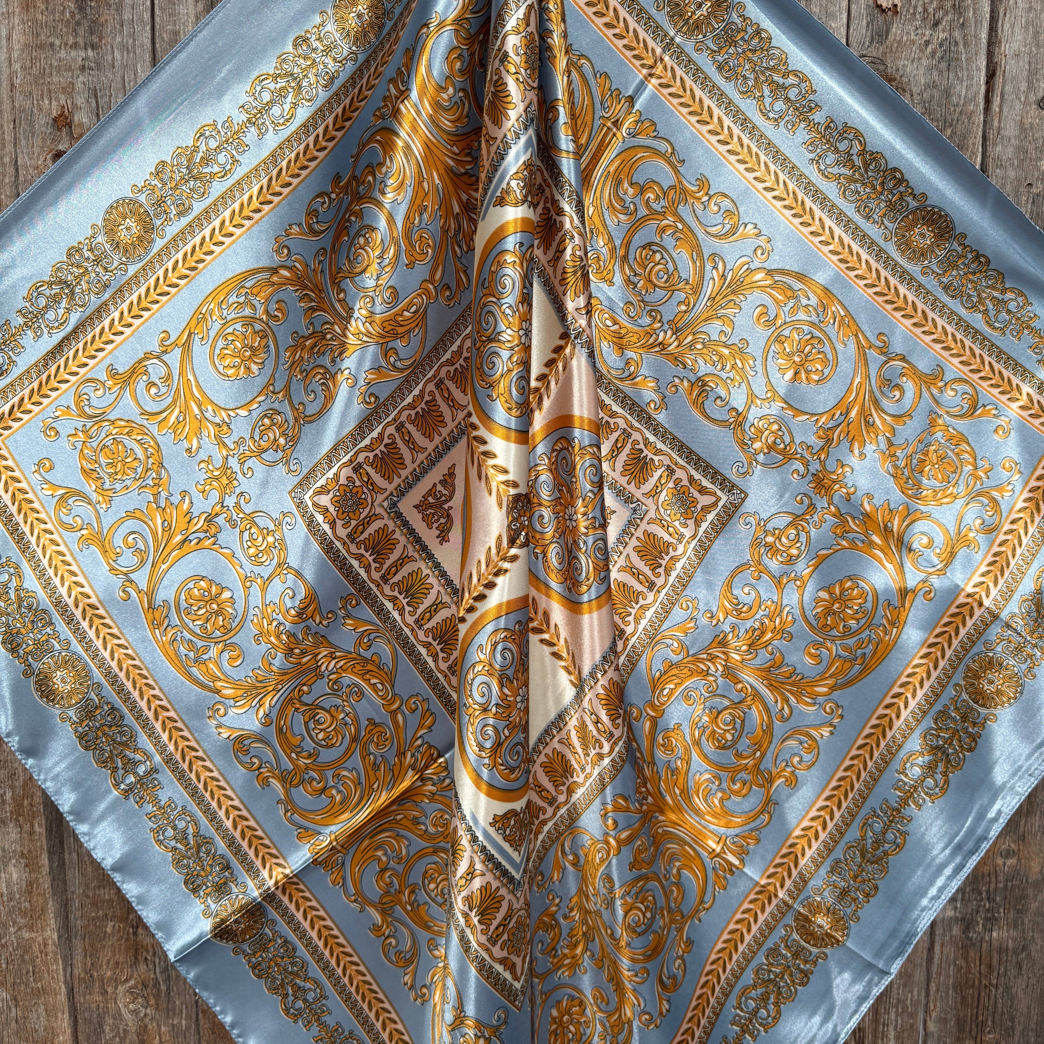 Decorative scarf with gold and blue pattern on a wooden surface