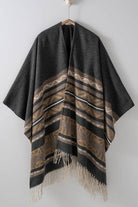 Dark gray poncho with brown and beige striped pattern and fringes on a white background